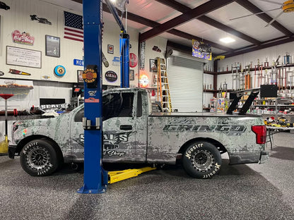 Side shot of a F150 in a shop featuring a chassis mounted wing