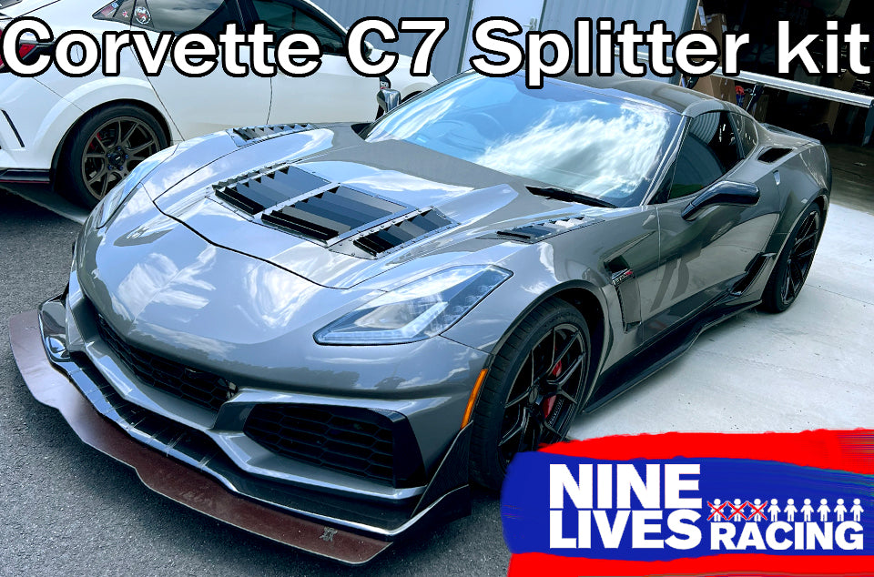 A sleek gray Corvette C7 with a newly installed Corvette splitter kit C7 featuring Sturdy Boii mounts is parked outside. The car's aggressive design includes a large hood vent and black accents that enhance downforce. In the background, another white sports car is partially visible. Text on the image reads "Corvette splitter kit C7 with Sturdy Boii mounts" and "9livesracing.