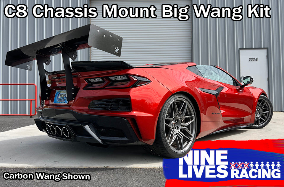 A red sports car, featuring a large black carbon fiber rear wing, is parked in front of a corrugated metal building with a white door numbered 1114. Text on the image reads: "Corvette Big Wang Chassis Mount ’2020 C8" and "9livesracing." This setup maximizes down-force while optimizing the lift-to-drag ratio.
