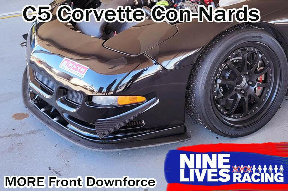 A close-up of the front end of a black C5 Corvette equipped with the C5 Corvette Car-Nards from Nine Lives Racing. The car boasts a front splitter and a "NASA" decal. The image highlights the increased front balance provided by the High Downforce kits and features the "Nine Lives Racing" logo in the bottom right corner.