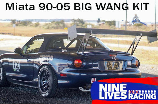 A blue Mazda Miata with a large rear wing is shown parked on a road. The car, enhanced with the Miata Big Wang Kit '90-05 NA/NB for optimal down-force, sports racing decals and a license plate reading "590-95." Text at the top reads "Miata Big Wang Kit '90-05 NA/NB," with a 9livesracing logo at the bottom right corner.