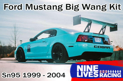 A blue Ford Mustang with a large rear wing spoiler kit attached, labeled with 'Nine Lives Racing' and the model years '99-04 SN95'.