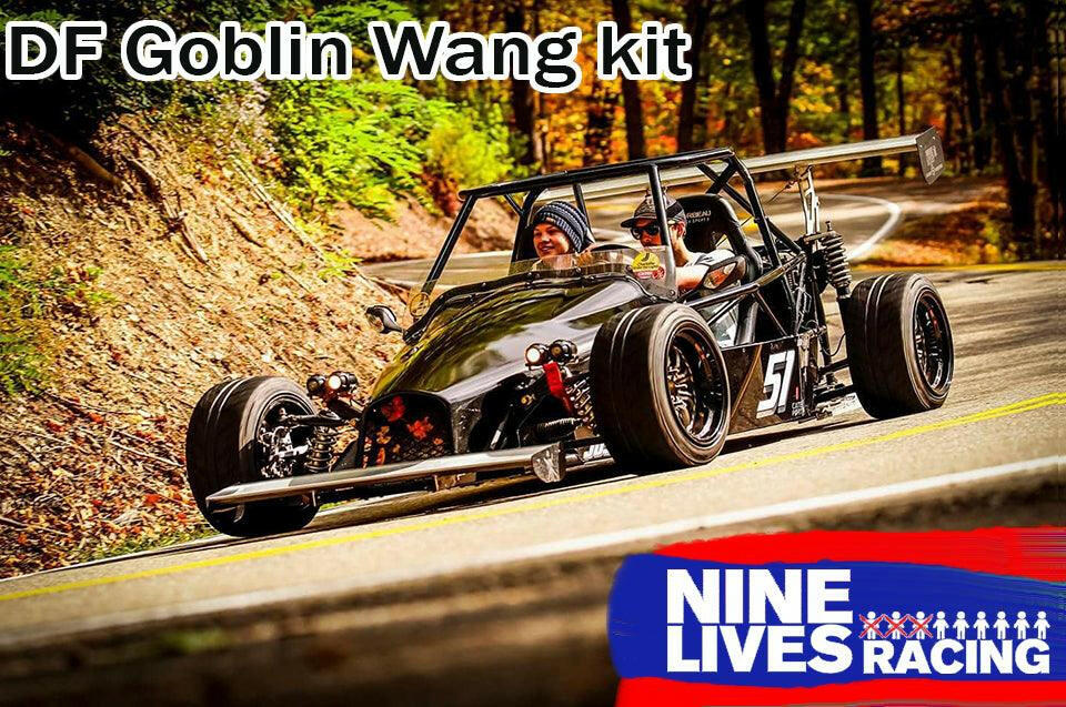 Two people drive a black open-wheel car with the number "57" on a winding road surrounded by trees. The text "DF Goblin Big Wang Kit" is at the top, beneath sleek aluminum wings, while a "9livesracing" logo graces the bottom right.